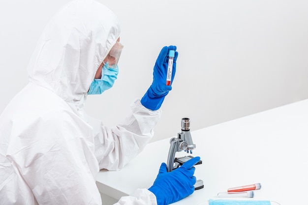 Man in hazmat suit with blood sample