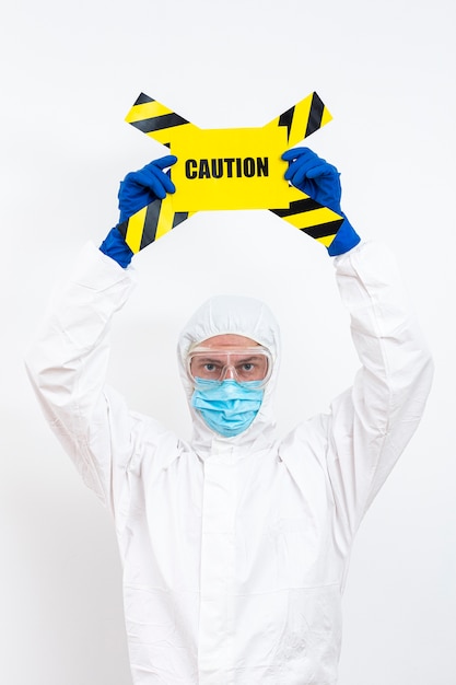 Free photo man in hazmat suit with danger sign