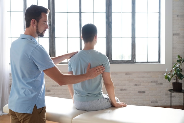 Man helping patient in physiotherapy medium shot