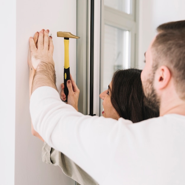 Free Photo man helping with nail to woman