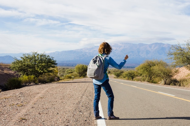 Man hitchhiking on the side of the road