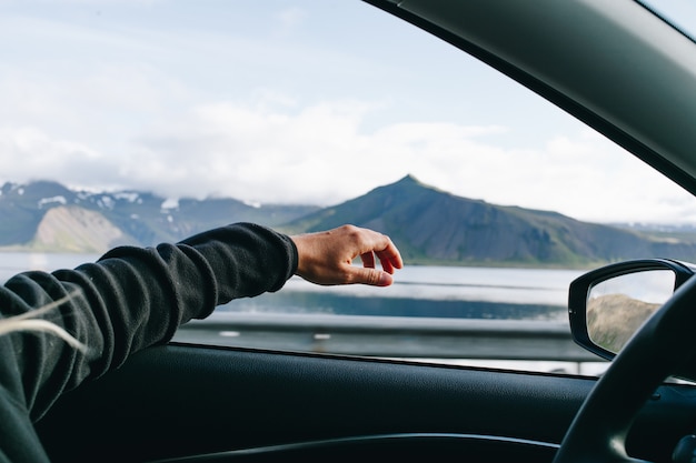 Man hold out hand when driving car