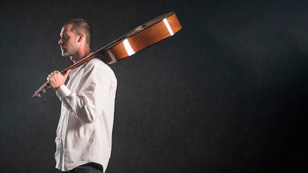 Man holding acoustic guitar in studio