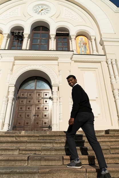 Free Photo man holding bible book outside the church