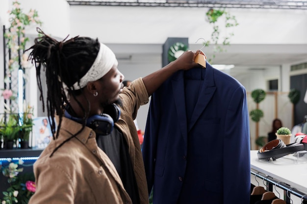 Man holding blazer in clothing store examining size