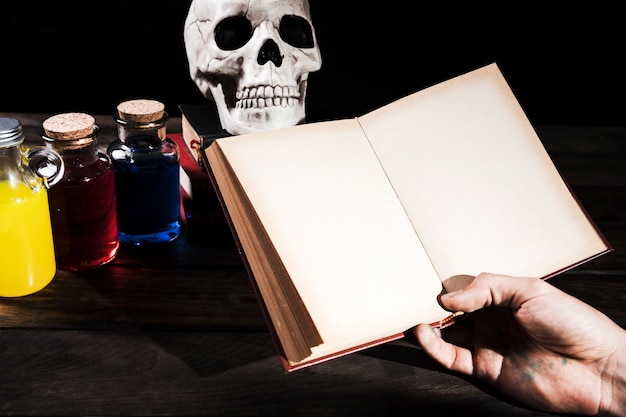 Man holding books on background with Halloween decorations