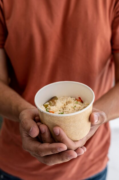 Man holding bowl of donated food