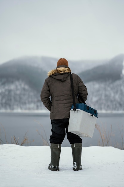 Free Photo man holding a box for the fish he caught