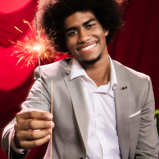 Free Photo man holding a burning sparkler blast