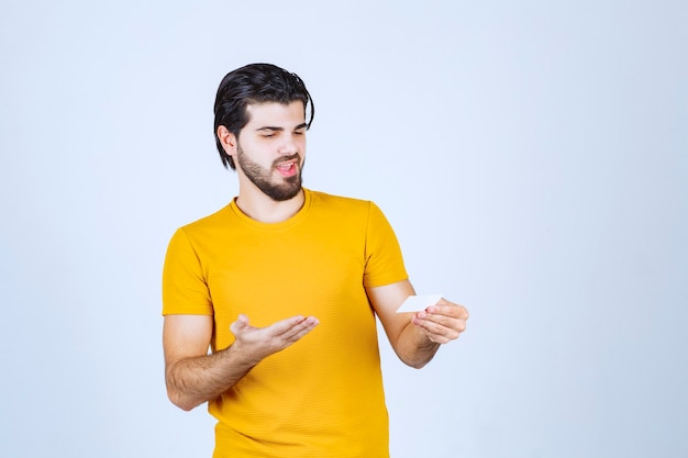 Man holding a business card and checking the contact details.