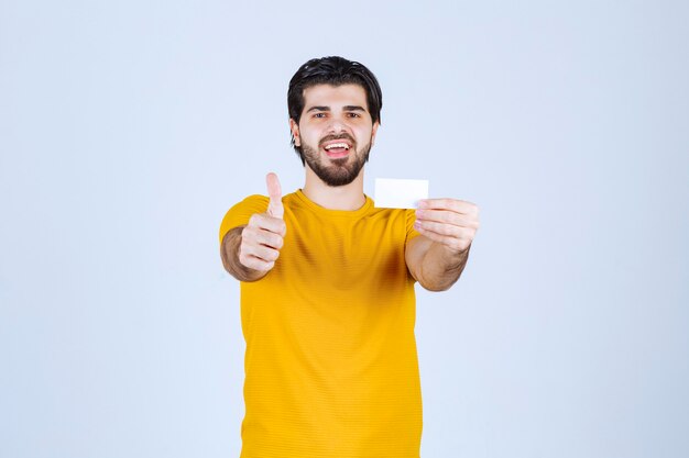 Man holding a business card and showing thumb up.