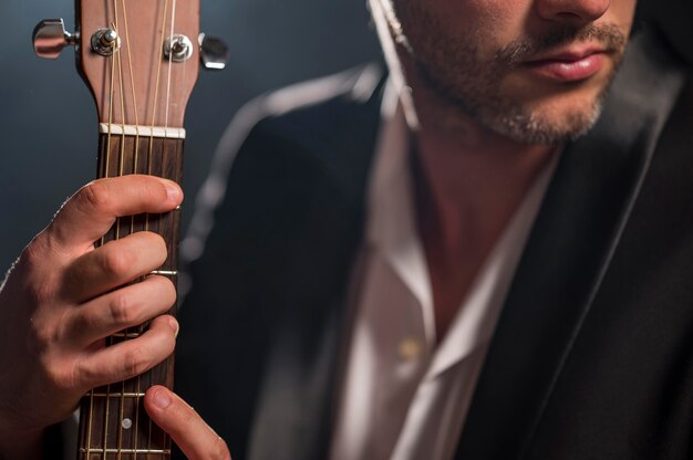 Man holding a chord on guitar close-up