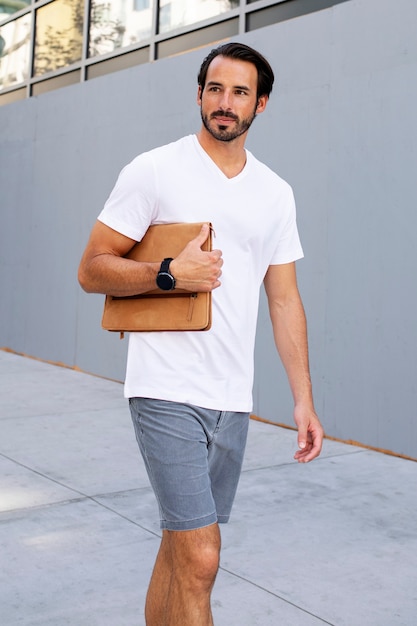 Man holding clutch walking in the city