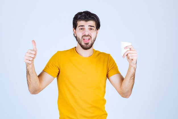 Man holding a coffee cup and enjoying the taste.