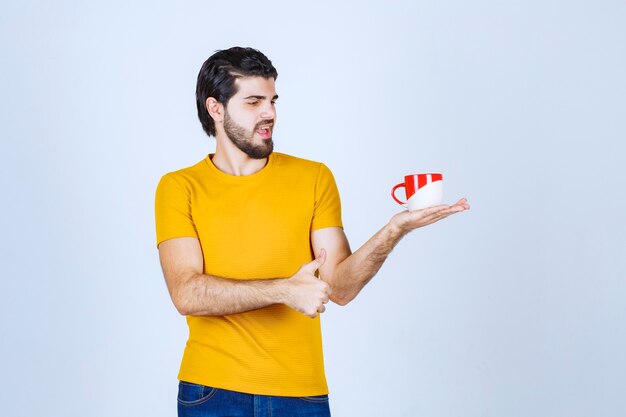 Man holding a coffee mug and enjoying the taste.