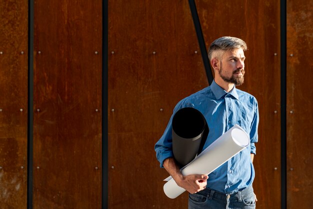 Man holding construction plan with copy space