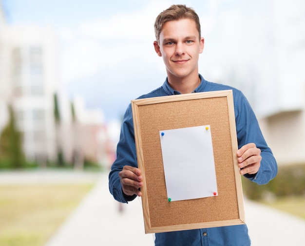 Free photo man holding a cork board