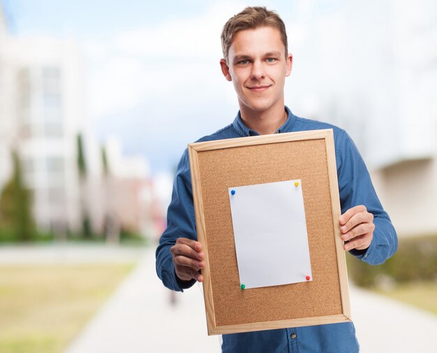 Man holding a cork board