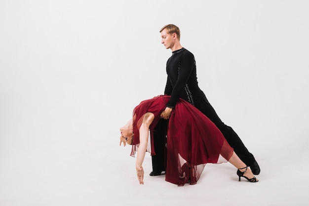 Man holding dance partner in red dress