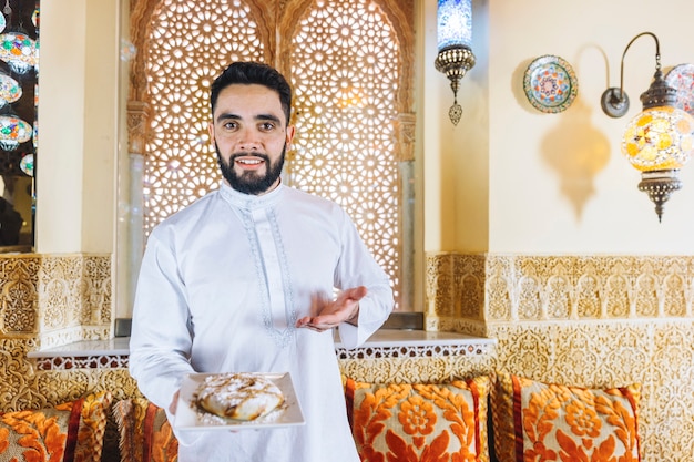 Free photo man holding dish of arab food