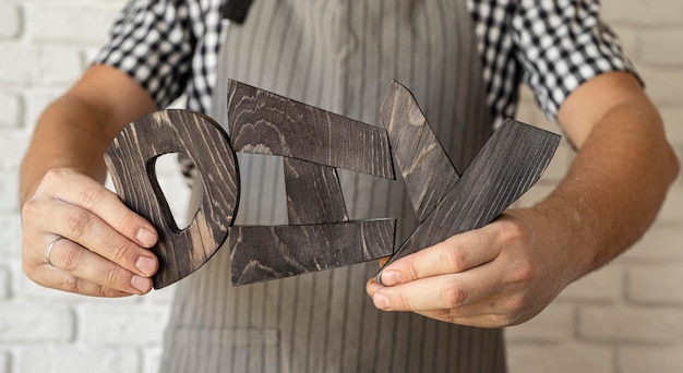 Free Photo man holding diy letters made out of wood