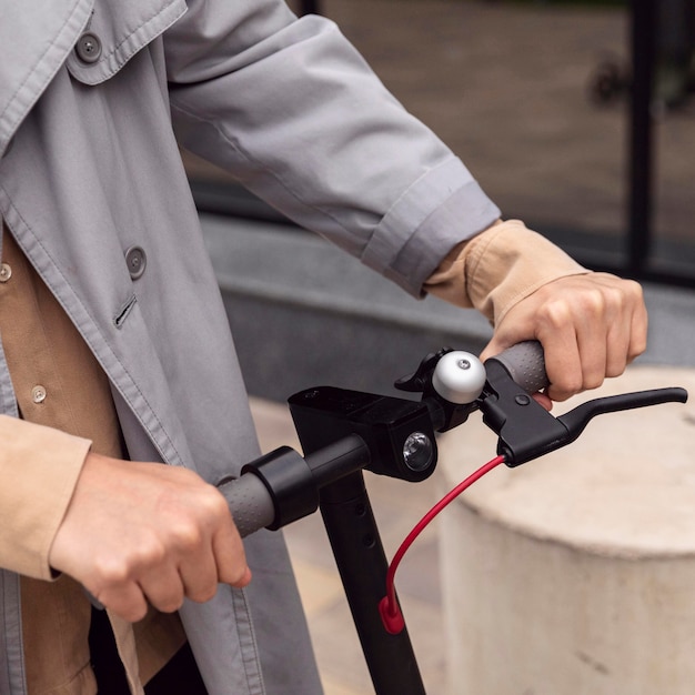 Free photo man holding electric scooter by the handle