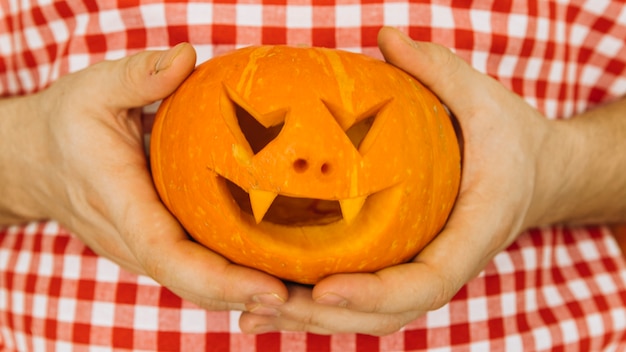 Free Photo man holding halloween jack-o-lantern