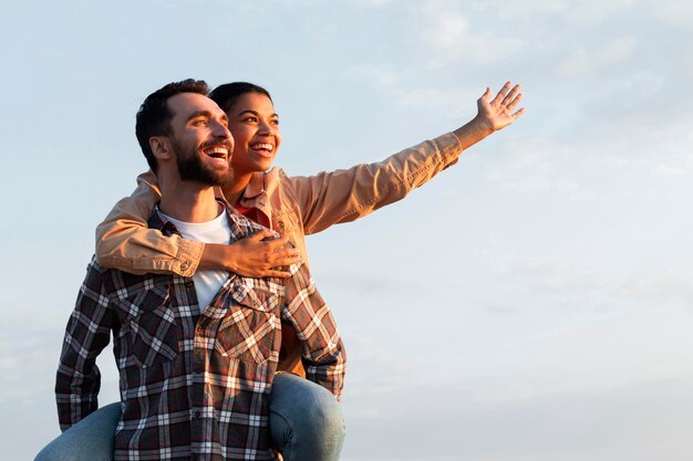 Man holding his girlfriend on his back with copy space