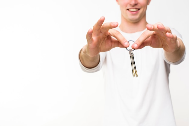 Free photo man holding keys with copyspace