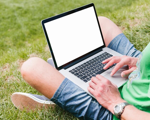 Man holding laptop in the park