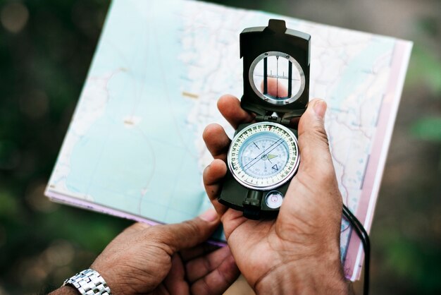 Man holding a map and a compass