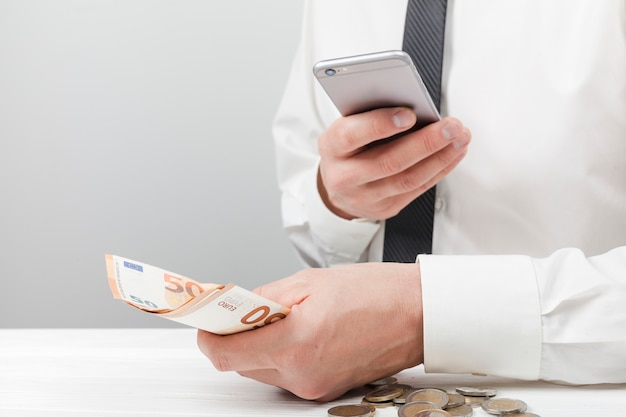 Man holding money and using calculator