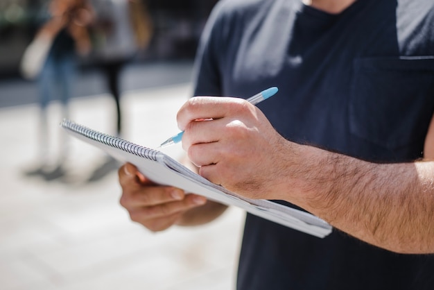 Free photo man holding notebook writing