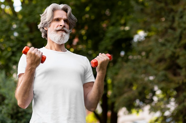 Man holding orange dumbbells at home