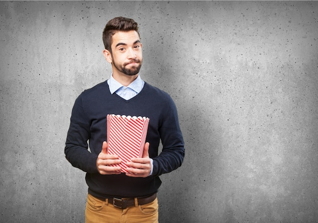 Man holding a packet of popcorn