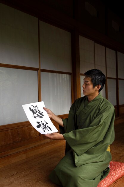 Man holding a paper with japanese handwriting