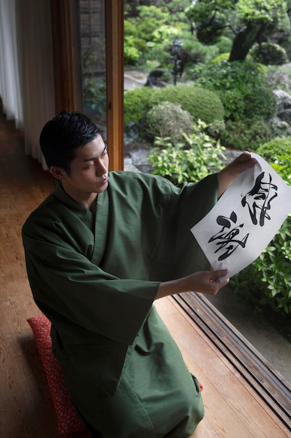 Man holding a paper with japanese handwriting