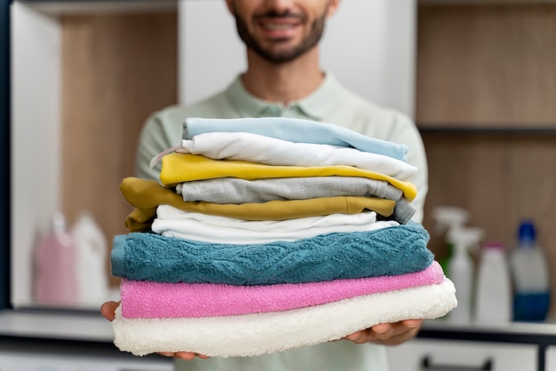 Man holding a pile of clean clothes