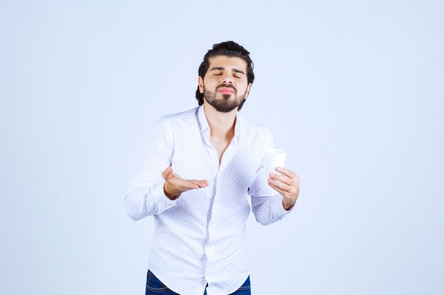 Man holding and promoting a coffee cup or coffee