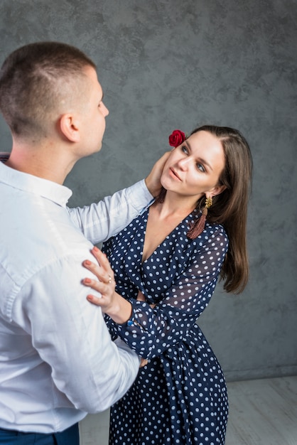 Man holding red rose at woman head 