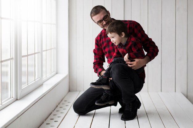 Man holding son on fathers day in front of chalkboard