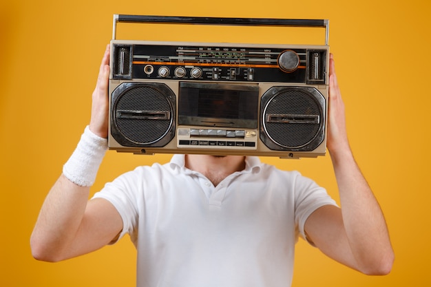 Man holding tape recorder covering face