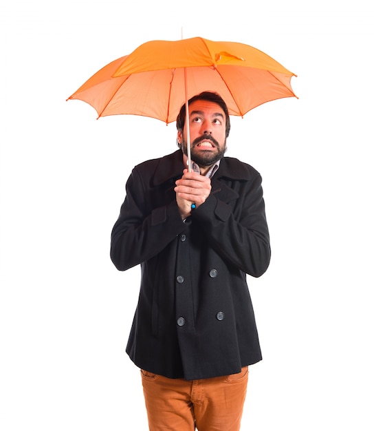 Free photo man holding an umbrella over white background