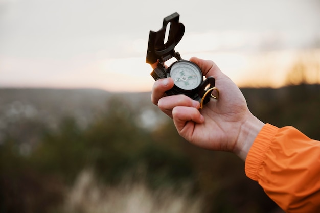 Free photo man holding up compass while on a road trip