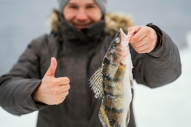 Man holding victoriously the fish he caught