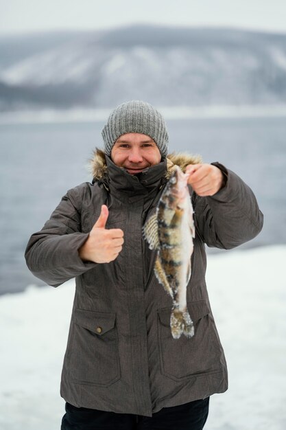 Man holding victoriously the fish he caught