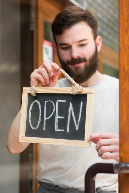 Free Photo man holding we are open sign