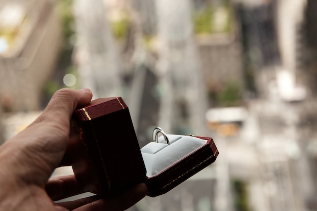 Free photo man holds red box with wedding rings