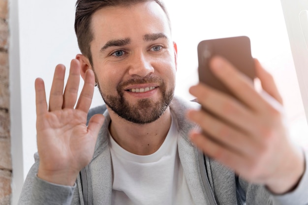 Free photo man at home having videocall with family