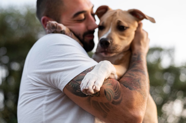 Free photo man hugging his friendly pitbull